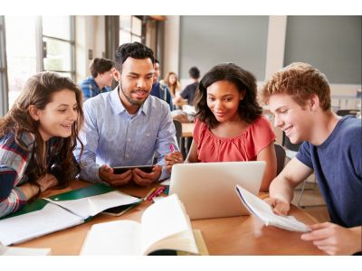 group of people working together and looking at a laptop