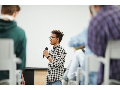 person standing in front of a crowd and speaking
