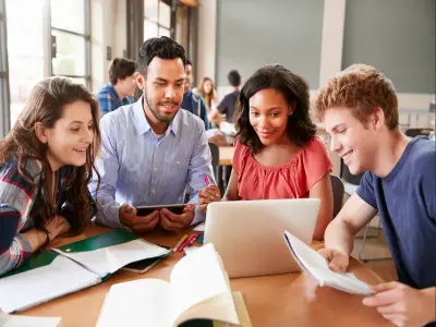 group of people working together and looking at a laptop