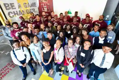 students stand while football players sit