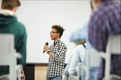 person standing in front of a crowd and speaking